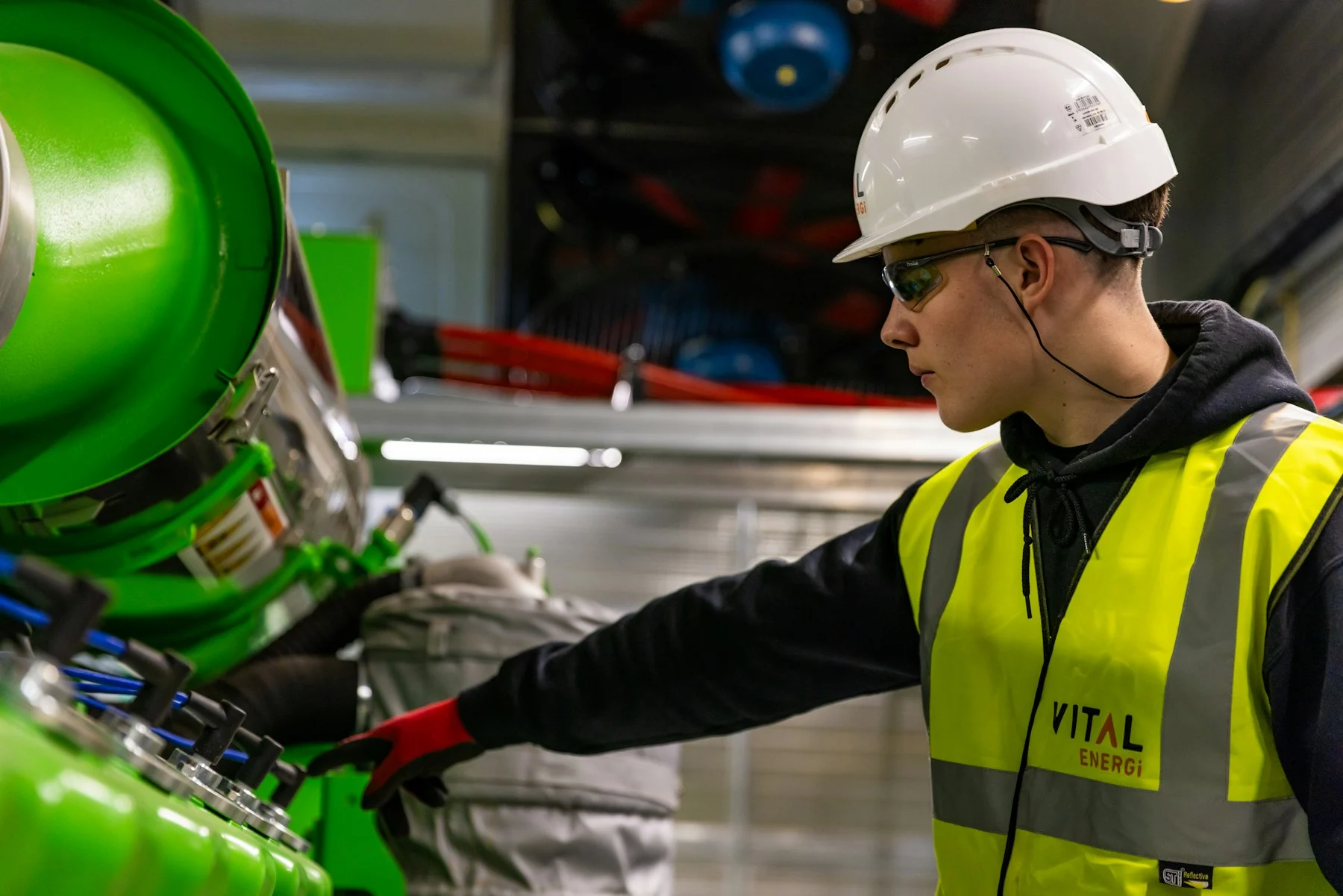 Worker in a hard hat and safety vest operating equipment